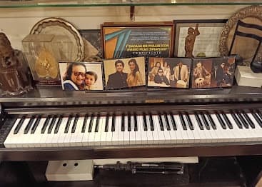 AudioQore Showroom — Upright Piano with Celebrity Memory Wall